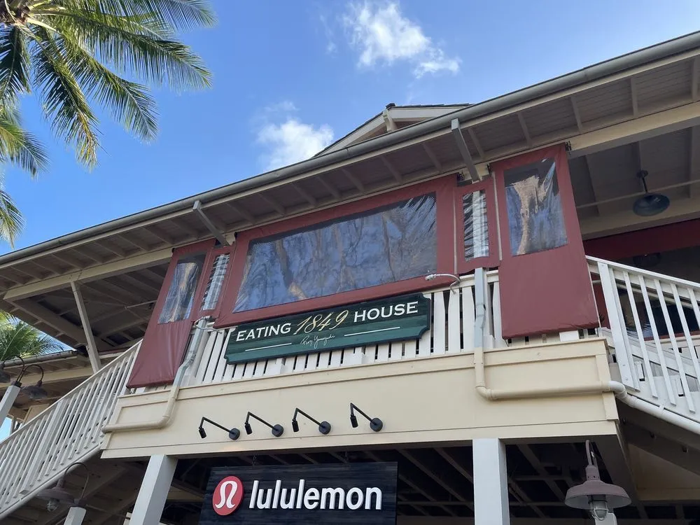 A building with a balcony, palm trees, and a sign reading "Eating House" and "lululemon".